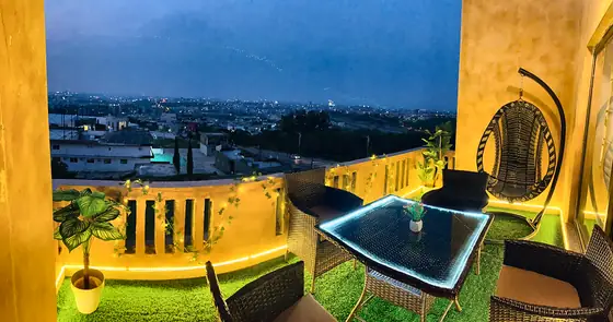Private terraces with a view. Turf lawns, glass-top rattan dining sets, hanging egg chairs and lantern lights, looking out over the city skyline.